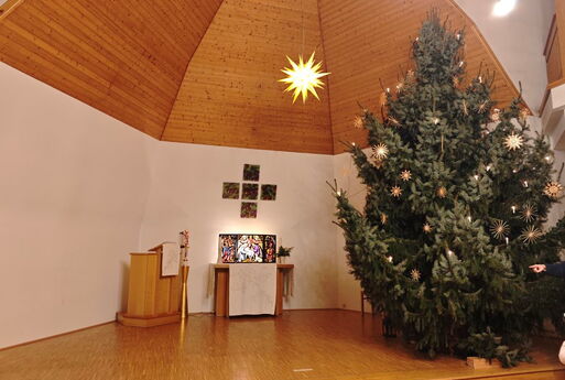 Kirche in Cossebaude in der Weihnachtszeit mit geschmücktem Weihnachtsbaum und Adventsstern in der Kuppel