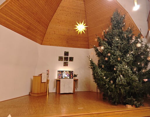 Kirche in Cossebaude in der Weihnachtszeit mit geschmücktem Weihnachtsbaum und Adventsstern in der Kuppel