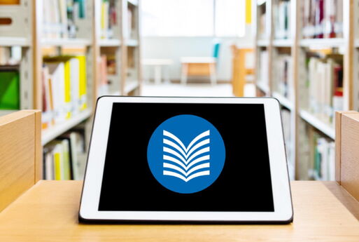 Vordergrund: Tablet mit dem Logo der Bibliothek | Hintergrund: Bücherregale