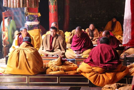 Ein Kloster in Tibet - Mehrere Mönche sind ins Gebet versunken.